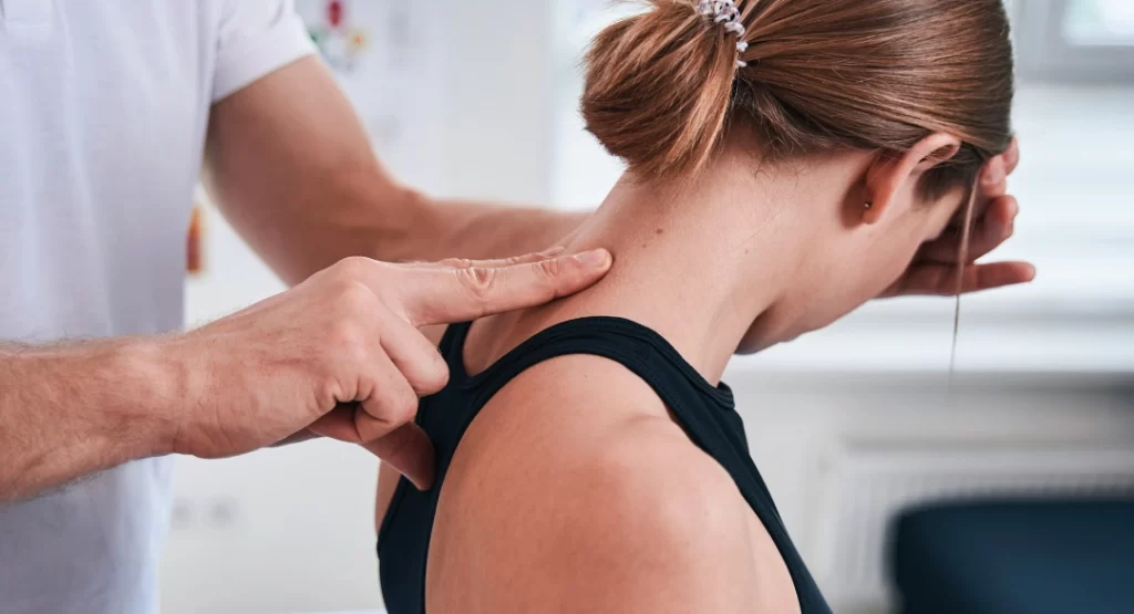 Kinesiólogo evaluando la postura cervical de una paciente para mejorar su descanso y respiración