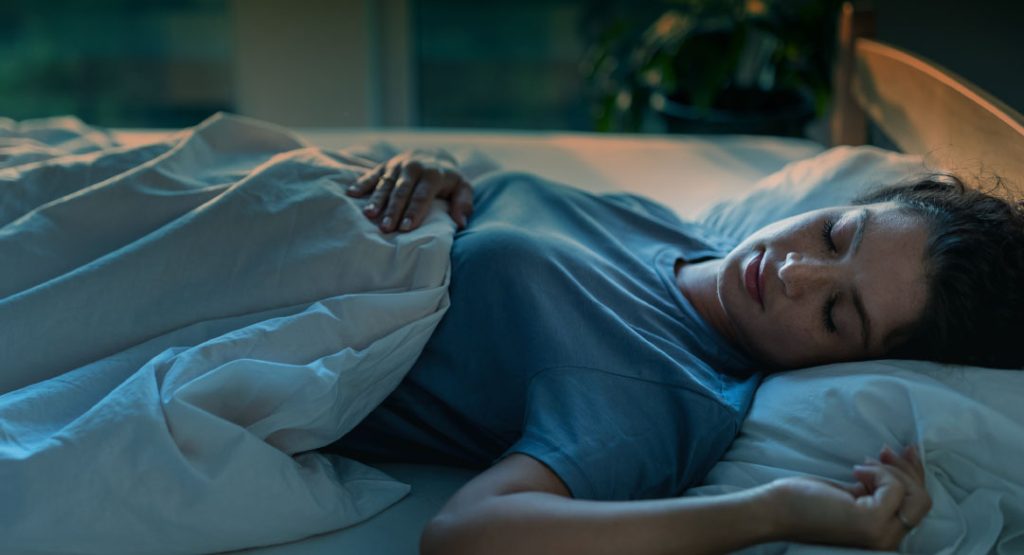 Mujer descansando mientras se evalúa la importancia del sueño en la recuperación pulmonar tras una neumonía